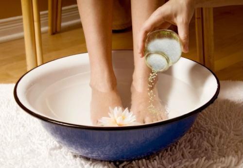 Ngâm chân với nước muối ấm làm giảm đau cho người bệnh gút