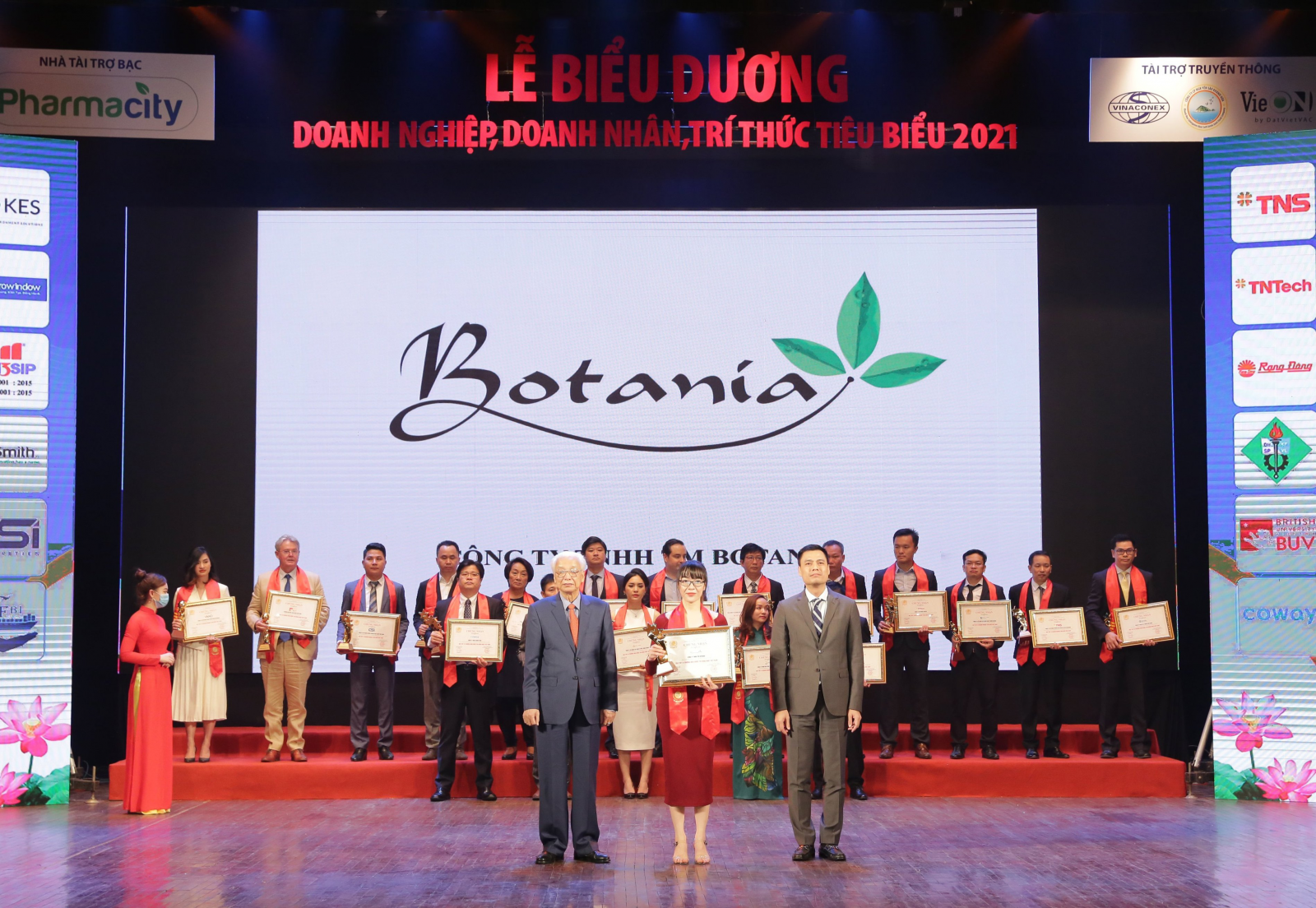 Đại diện công ty Botania lên nhận giải thưởng do ông Đặng Hoàng Giang - Thứ trưởng Bộ Ngoại giao và ông Cao Sỹ Kiêm – Nguyên thống đốc ngân hàng nhà nước Việt Nam trao tặng